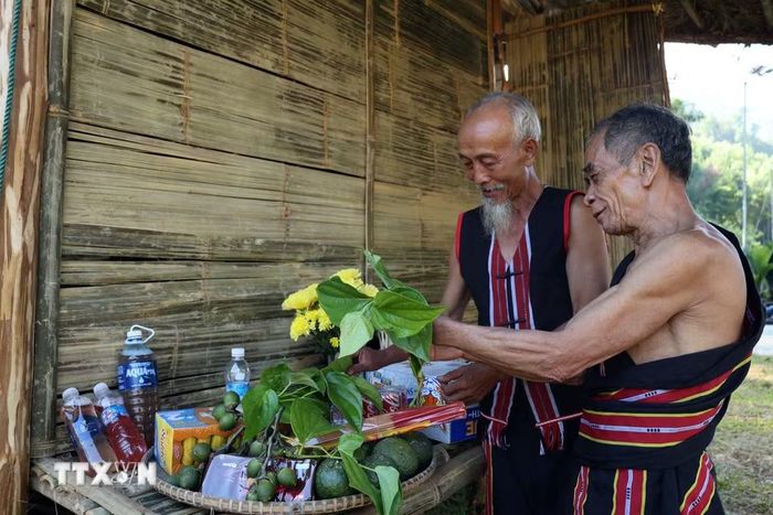 Hai già làng chuẩn bị lễ vật trước khi bước vào Lễ cúng máng nước của đồng bào M’Nông. (Ảnh: Đỗ Trưởng/TTXVN)