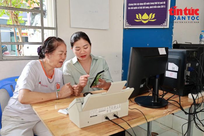 Bà Đỗ Thị Lục (bên trái) tìm hiểu cách thực hiện thủ tục trực tuyến tại điểm hỗ trợ dịch vụ công ở Khu phố 13 và 14 phường Tân Bình, TP Hồ Chí Minh.