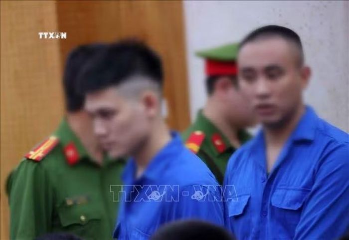 Dẫn giải các bị cáo vào phòng xét xử tại điểm cầu hội trường Trại tạm giam số 1 (Công an Hà Nội). Ảnh: Văn Điệp/TTXVN