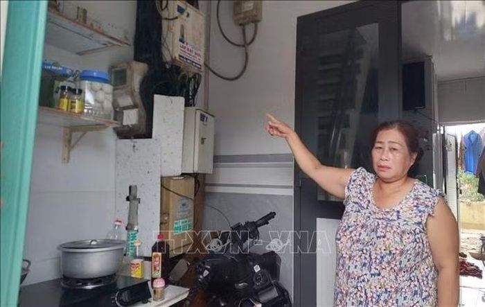 Nơi để xe máy và khu vực bếp nấu ăn hàng ngày của gia đình chị Lâm Kim Huốn phải đặt ngay dưới bó dây điện, tiềm ẩn nguy cơ cháy nổ nguy hiểm.
