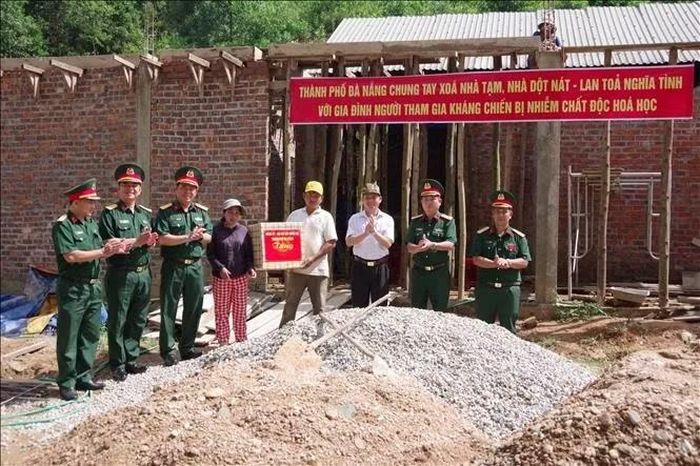 Đại tá Đinh Văn Hưng, Chính ủy Bộ Chỉ huy Quân sự thành phố Đà Nẵng, tặng quà gia đình thuộc diện xóa nhà tạm tại xã Sông Kôn. Ảnh: Khoa Chương - TTXVN