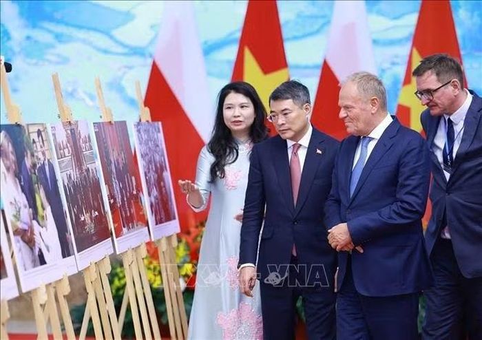Thủ tướng Lê Minh Hưng và Thủ tướng Cộng hòa Ba Lan Donald Tusk tham quan trưng bày ảnh về quan hệ hợp tác hai nước do Thông tấn xã Việt Nam thực hiện. Ảnh: Dương Giang/TTXVN