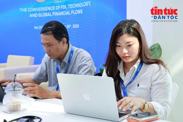 Phóng viên Cao Tân, Báo Nhân dân và Kim Thoa, Tạp chí điện tử chất lượng Việt Nam đang tác nghiệp tại khu vực dành cho báo chí.
