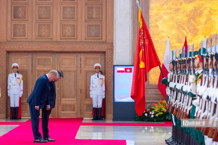 Sau khi nghe quân nhạc cử Quốc thiều hai nước, Thủ tướng Lê Minh Hưng và Thủ tướng Donald Tusk bước tới cúi chào quân kỳ.