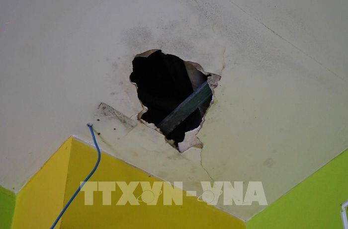 Vì bị thấm dột nước trong thời gian dài nên trần nhà bị thủng. Ảnh: Nhựt An - TTXVN