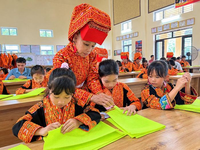  Bà Triệu Thị Phẩy hướng dẫn trẻ em thôn Đá Bờ học thêu. 