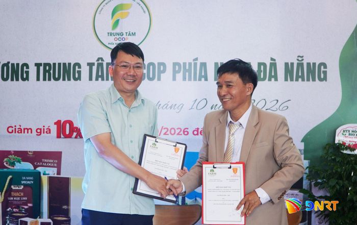 Ông Trần Văn Hùng (bên phải) và ông Lại Châu Quang (bên trái) ký kết hợp tác phát triển mạng lưới thương mại sản phẩm OCOP Bắc - Trung. Ảnh: PHAN VINH