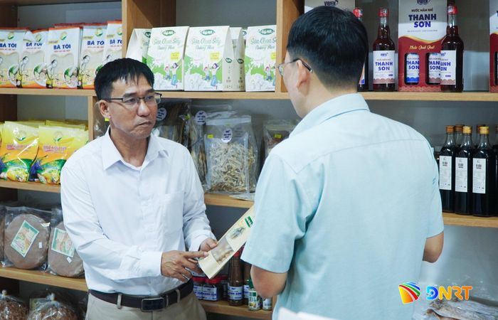 Ông Trầm Văn Hùng (bên trái) chủ động kết nối với nhiều chủ thể OCOP đưa sản phẩm vào trung tâm. Ảnh: PHAN VINH