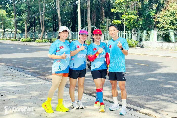 Đại sứ Hoàng Nguyên Thanh cùng vận động viên nữ của CLB Rnnner Bình Phước chek in chụp hình lưu niệm sau buổi tập luyện. Ảnh Minh Huệ