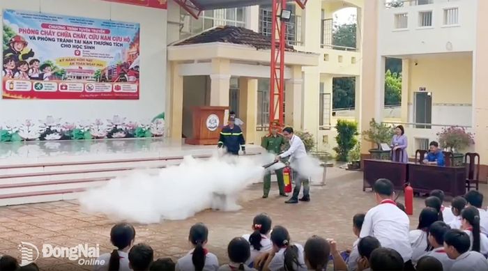 Cán bộ, giáo viên và học sinh nhà trường trải nghiệm thực hành sử dụng bình chữa cháy xách tay.