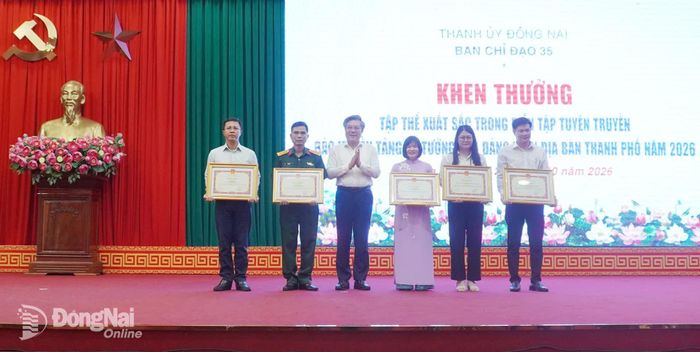 Đồng chí Dương Minh Dũng chúc mừng 5 tập thể được trao Bằng khen của UBND thành phố có thành tích xuất sắc trong diễn tập lan tỏa thông tin tích cực, bảo vệ nền tảng tư tưởng của Đảng năm 2026. Ảnh: Phương Hằng