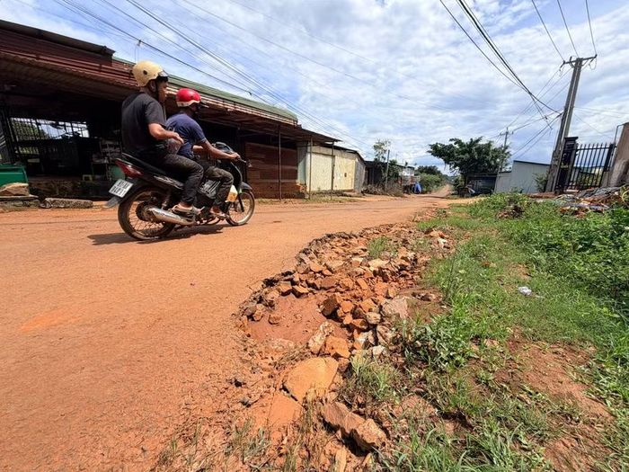 Đường bị xói lở, lộ ra những viên đá to nguy hiểm. Ảnh: Văn Ngọc