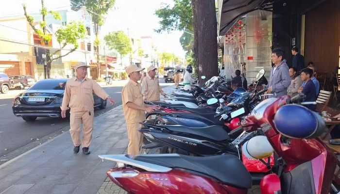 Lực lượng chức năng nhắc nhở các hộ kinh doanh chấp hành quy định về sử dụng vỉa hè. Ảnh: Bá Bính