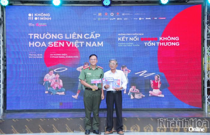 Thiếu tá Vũ Huy Phương - Phó Trưởng Phòng An ninh mạng, Công an tỉnh Khánh Hòa trao tặng cẩm nang tuyên truyền về an toàn trên không gian mạng cho đại diện nhà trường.