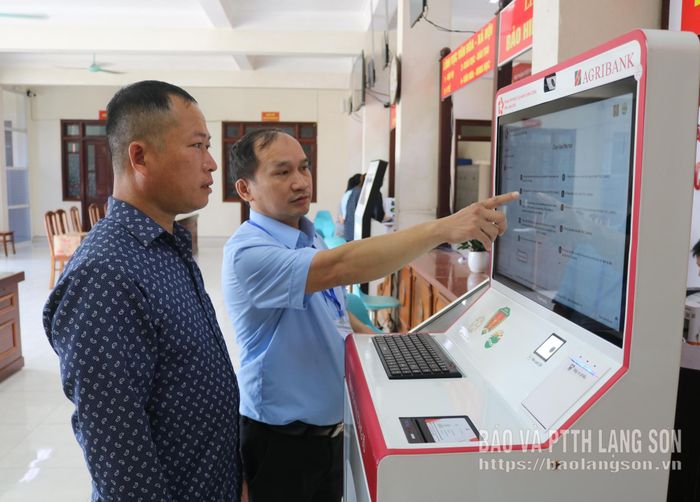 Cán bộ Trung tâm PVHCC xã Thất Khê hướng dẫn người dân sử dụng "Trạm Dịch vụ công số" thực hiện TTHC