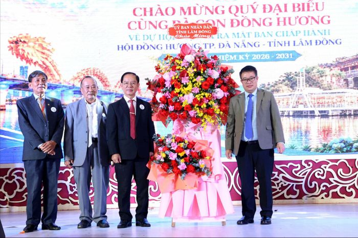 Đồng chí Nguyễn Ngọc Phúc, Tỉnh ủy viên, Phó Chủ tịch UBND tỉnh Lâm Đồng (bên phải) tặng hoa chúc mừng Hội đồng hương TP Đà Nẵng - tỉnh Lâm Đồng