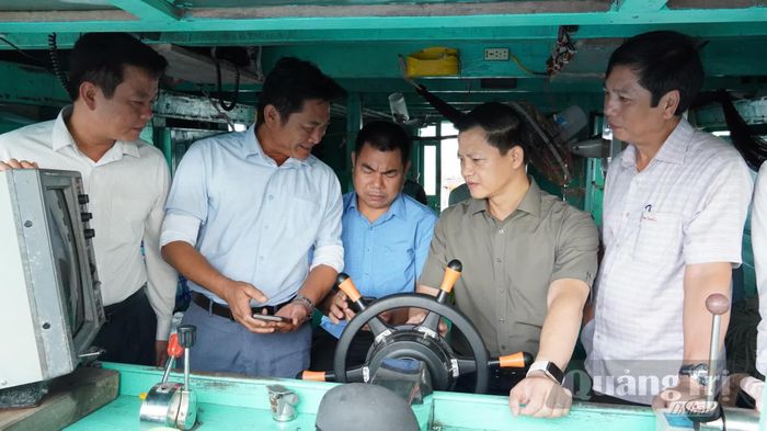Đồng chí Vương Quốc Tuấn, Bí thư Tỉnh ủy nghe báo cáo về hành trình khai thác thủy sản của chủ tàu cá - Ảnh: Q.V