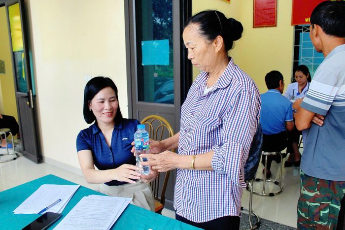 Cán bộ Bệnh viện Tâm thần Vĩnh Phúc phát nước miễn phí cho người dân xã Tam Dương tại buổi khám.
