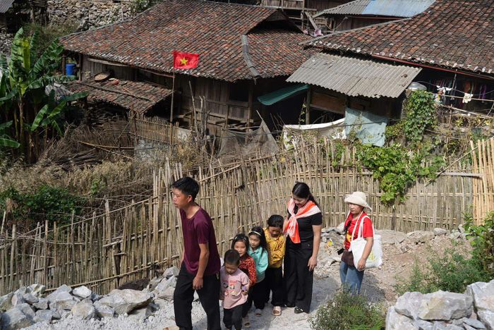 Bí thư Chi bộ xóm Cà Lò đưa các em nhỏ lên con đường mới mở. Ảnh: Nguyễn Ánh