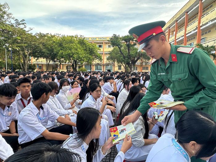 Tiểu đoàn 519 trao tờ gấp tuyên truyền pháp luật cho học sinh Trường THPT Nguyễn Thần Hiến. Ảnh: Phương Vũ