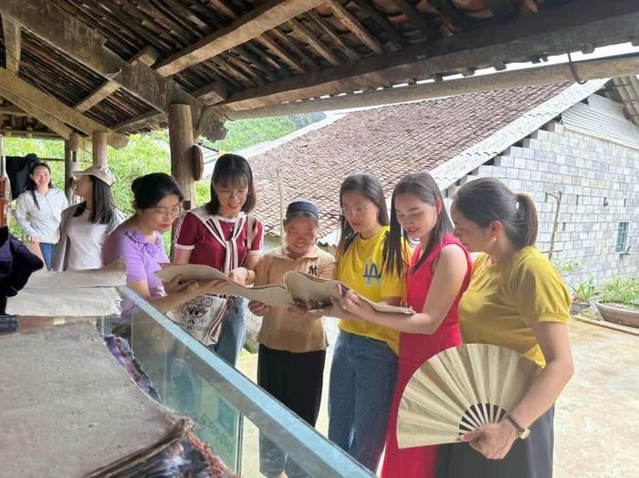 Du khách trải nghiệm nghề giấy bản của người Nùng An tại xóm Dìa Trên, xã Quảng Uyên trong vùng Công viên địa chất toàn cầu UNESCO Non nước Cao Bằng.
