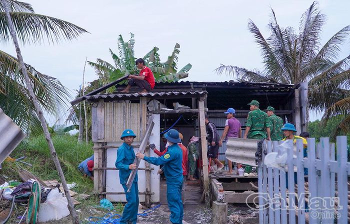 Lực lượng công an, quân sự xã, biên phòng phối hợp cùng người dân hỗ trợ gia đình ông Bùi Văn Lộc khắc phục hậu quả vụ cháy.