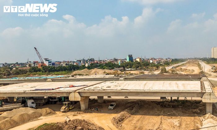 Nhìn từ trên cao, đường song hành thuộc dự án Vành đai 4 tại khu vực này về cơ bản đã hoàn thành. Trong khi đó, các hạng mục cầu vượt và đường dẫn tiếp tục được triển khai.