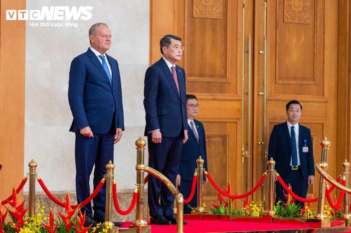 Trong tiếng nhạc chào mừng, Thủ tướng Lê Minh Hưng và Thủ tướng Donald Tusk bước lên bục danh dự tại sảnh chính trụ sở Chính phủ. Quân nhạc cử Quốc thiều hai nước.