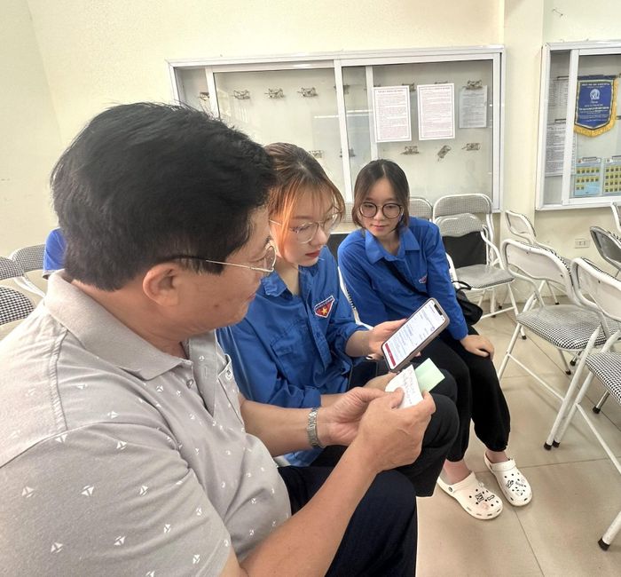 Đoàn viên thanh niên phường Long Biên hướng dẫn người dân sử dụng dịch vụ công trực tuyến. Ảnh: PV