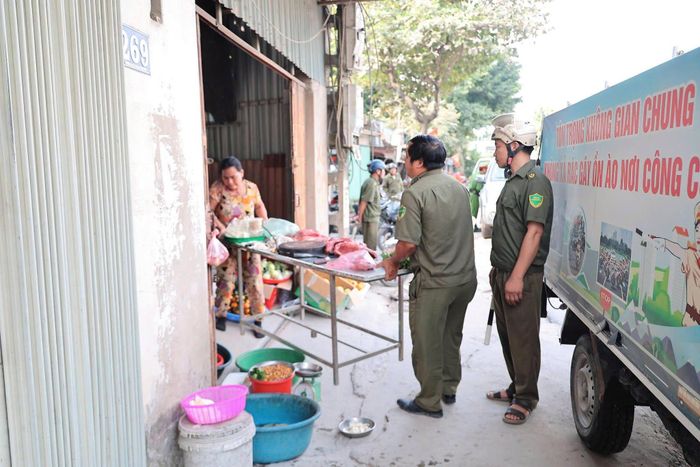 Các lực lượng hỗ trợ người dân thu dọn hàng hoá khỏi khu vực vỉa hè, lòng đường. Ảnh: Lê Hoa