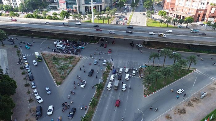 Những ngày gần đây, khu vực nút giao Mễ Trì - Dương Đình Nghệ, phía Tây Hà Nội, có nhiều thay đổi. Tại các tuyến đường dẫn vào nút giao, công nhân cùng máy móc chuyên dụng tiến hành cắt tỉa cành, đào gốc, đánh chuyển cây xanh trên vỉa hè và dải phân cách. Một số cây được chặt hạ, thân và cành cây tập kết tạm thời tại hiện trường. Cùng với đó, một phần vỉa hè được xén, tạo mặt bằng phục vụ triển khai công trình. Ảnh: NT