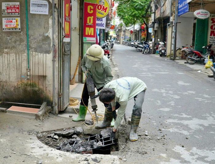 Công nhân thi công cải tạo hệ thống rãnh thoát nước tại một tuyến ngõ trên địa bàn phường Thanh Xuân. Ảnh: Tùng Lâm