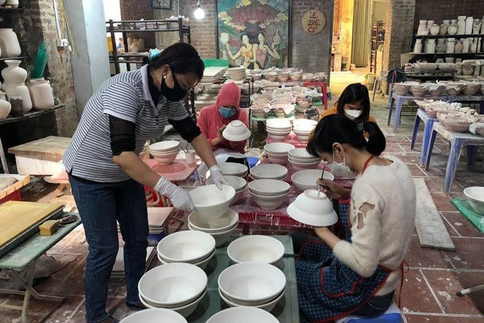 Những người thợ tại làng gốm Bát Tràng miệt mài hoàn thiện sản phẩm thủ công qua từng công đoạn. Ảnh: PV