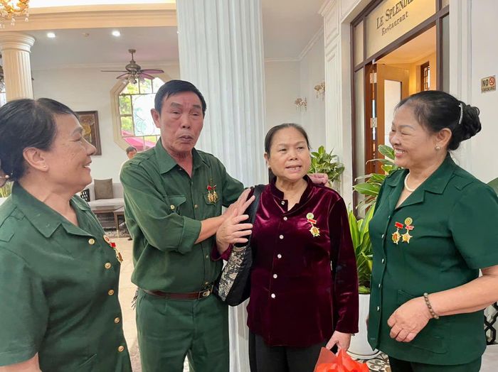 Ông Đỗ Văn Mã thăm hỏi người đồng đội, bà Đỗ Thị Chúc (áo đỏ), người nữ cựu thanh niên xung phong tiền trạm vẫn mang trong mình những mảnh đạn. Ảnh: Bảo Lâm