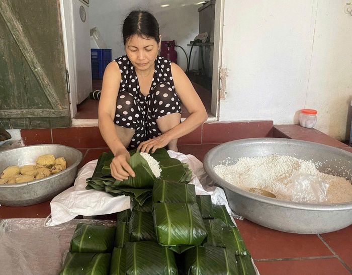 Đôi bàn tay khéo léo và hành trình 27 năm gắn bó với nghề gói bánh chưng truyền thống tại Tranh Khúc của bà Chử Thị Lịch. Ảnh: PV