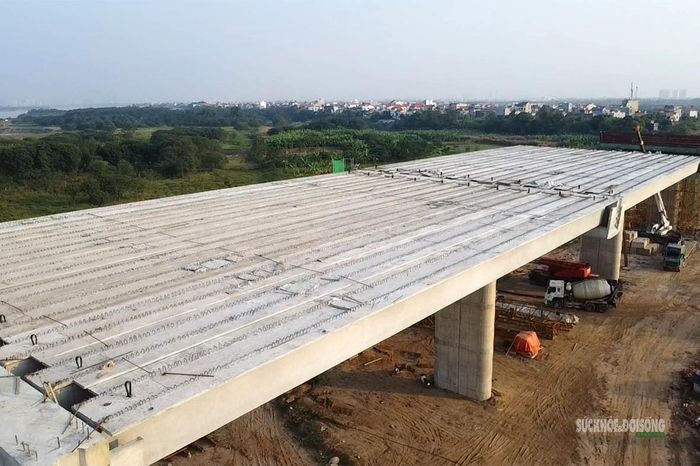 Hệ thống trụ cầu, bãi tập kết dầm và máy móc trải dài trên công trường hướng ra sông Hồng. Ảnh: Tuấn Anh