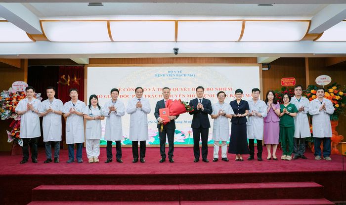 Thứ trưởng thường trực Bộ Y tế Vũ Mạnh Hà, Ban Giám đốc và Đảng uỷ Bệnh viện Bạch Mai tặng hoa chúc mừng TS.BS Nguyễn Ngọc Hùng. Ảnh: Thế Anh