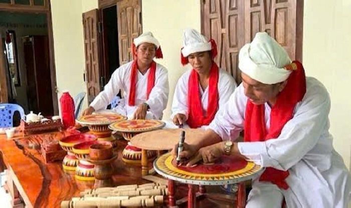 Phó Cả sư Nại Cao Liêm hướng dẫn các chức sắc trang trí hoa văn và vẽ màu trên mâm gỗ