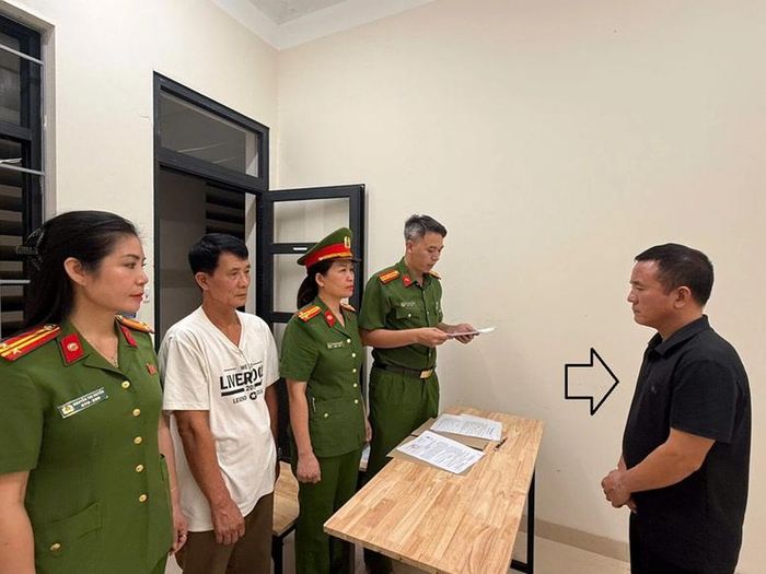 Cơ quan chức năng tống đạt các quyết định tố tụng đối với bị can Bùi Đình Chung (áo đen) . Ảnh: BCA
