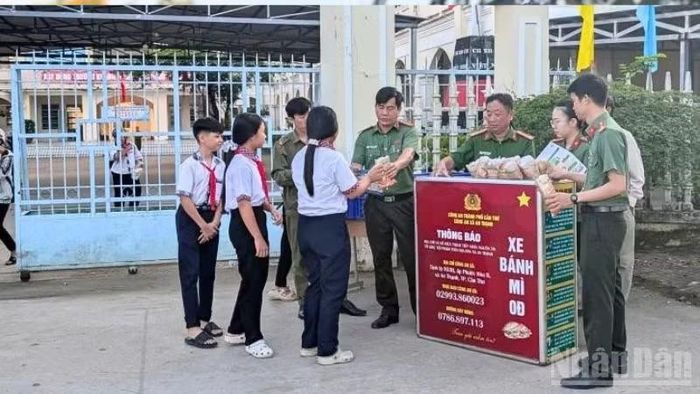 Mô hình “Xe bánh mì 0 đồng” và tuyên truyền pháp luật cho học sinh trước cổng trường của Công an xã An Thạnh. (Ảnh: HẢI ĐĂNG)
