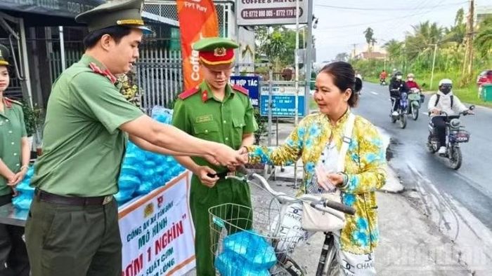 Công an xã Tân Bình chuẩn bị các phần cơm và trao tận tay suất “Cơm 1 nghìn” cho người lao động nghèo. (Ảnh: HẢI ĐĂNG)