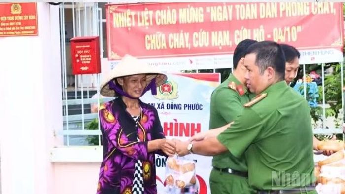 Công an xã Đông Phước phối hợp cùng các đoàn thể chuẩn bị và trao các phần bánh mì cho người dân. (Ảnh: HẢI ĐĂNG)