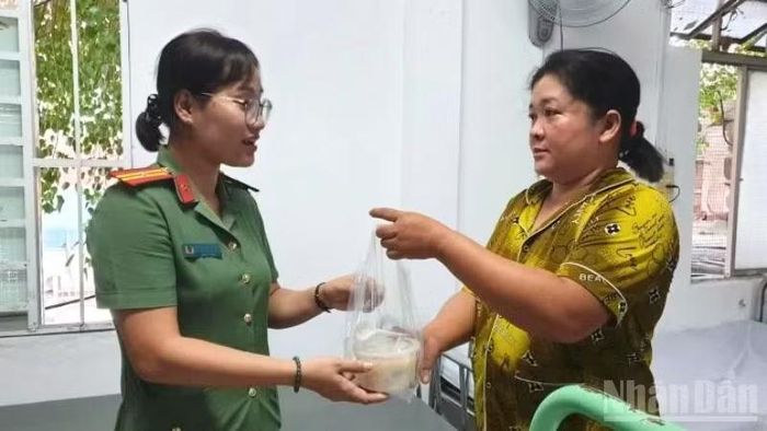 Cán bộ, chiến sĩ trao tận tay những phần cháo cho bệnh nhân và thân nhân tại Bệnh viện Ung bướu từ mô hình “Suất ăn nghĩa tình”. (Ảnh: HẢI ĐĂNG)