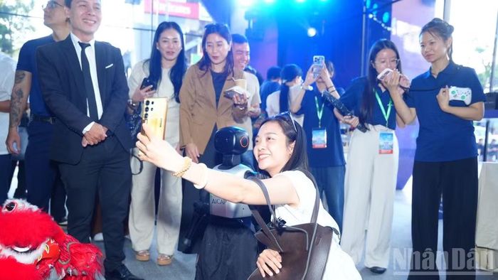 Các đại biểu chụp hình cùng robot tại sự kiện. (Ảnh: CTV)