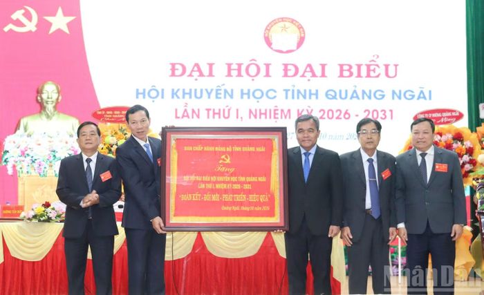 Ủy viên Trung ương Đảng, Bí thư Tỉnh ủy Quảng Ngãi Hồ Văn Niên trao tặng bức trướng của Tỉnh ủy Quảng Ngãi mang dòng chữ “Đoàn kết- Đổi mới- Phát triển- Hiệu quả” cho Hội Khuyến học tỉnh Quảng Ngãi. (Ảnh: HIỂN CỪ)