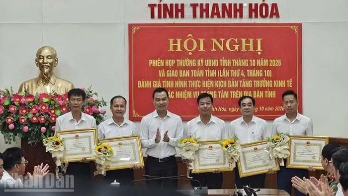 Chủ tịch tỉnh Thanh Hóa trao tặng bằng khen cho tập thể, cá nhân ở xã Hoằng Thanh có thành tích xuất sắc trong giải phóng mặt bằng thực hiện dự án đầu tư công. (Ảnh: Mai Luận)
