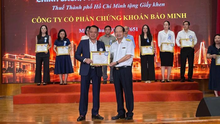 Ông Nguyễn Tiến Dũng, Phó Trưởng Thuế Thành phố Hồ Chí Minh tặng giấy khen của Thuế thành phố cho các doanh nghiệp. (Ảnh: A.T)
