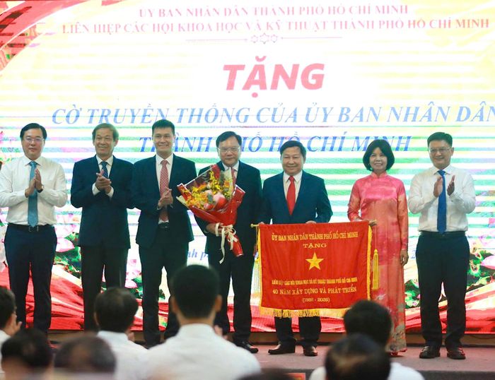 Phó Bí thư Thường trực Thành ủy TPHCM Lê Quốc Phong và Phó Chủ tịch UBND TPHCM Nguyễn Mạnh Cường trao cờ truyền thống của UBND TPHCM đến Liên hiệp các Hội Khoa học và Kỹ thuật TPHCM. Ảnh PHƯƠNG UYÊN