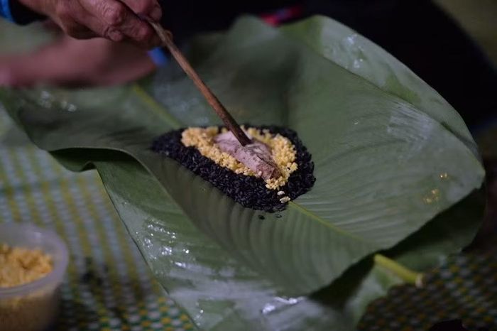 Bánh chưng đen Bắc Hà hấp dẫn thực khách bởi sự kết hợp của nhiều tầng hương vị. Gạo nếp mang đến độ dẻo mềm, đậu xanh tạo vị bùi, thịt lợn ba chỉ đem lại độ béo ngậy, trong khi tiêu và thảo quả làm nổi bật hương thơm đặc trưng. Ảnh: Phạm Khánh Huy