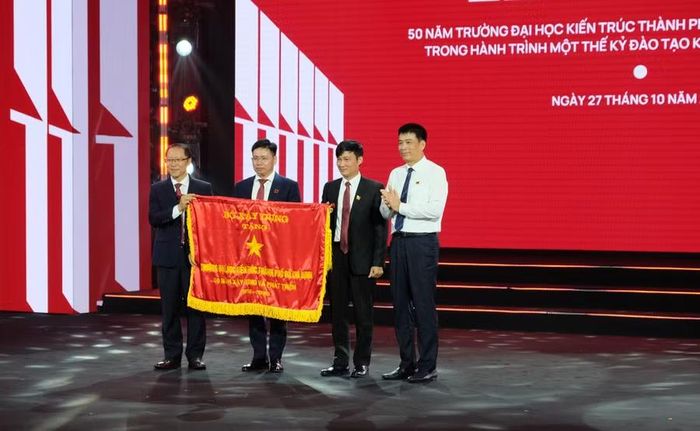 Thứ trưởng Bộ Xây dựng Phạm Minh Hà tặng cờ thi đua của Bộ Xây dựng cho Trường Đại học Kiến trúc TPHCM. Ảnh: Mạnh Tùng.